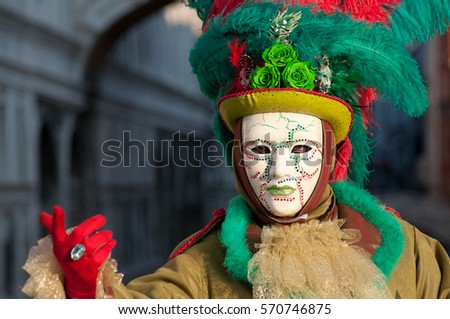 Beautiful mask in a red and green costume at carnival in Venice