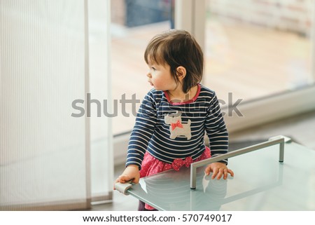 household safety of the children. girl standing at the table with the protection on the corners