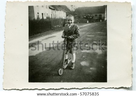 Vintage photo of boy with a scooter