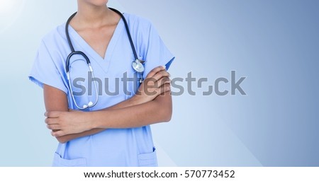 Female doctor with stethoscope standing with arms crossed against blue background