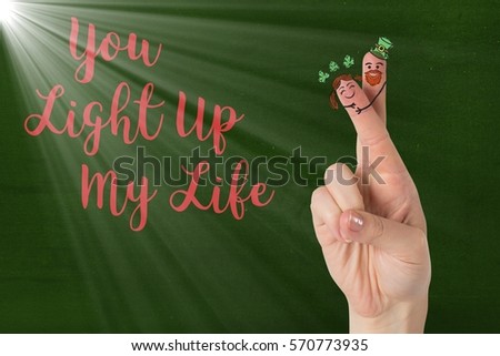 Digitally generated image of fingers with smiley face and love message against green background