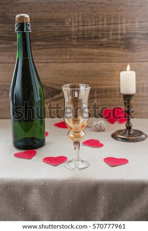 Valentine's Day. wine, candles, small heart on the wooden background