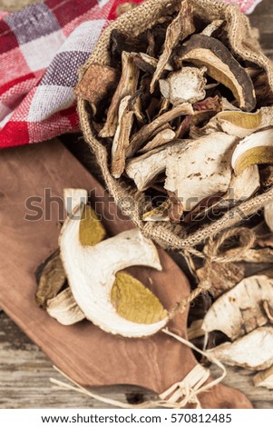 Wild edible dehydrated mushrooms on an old wooden background.