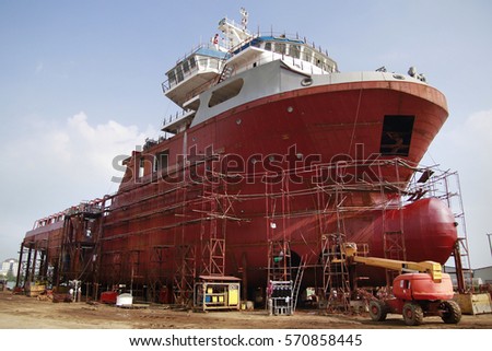 Shipyard industry ,( ship building) Big ship on floating dry dock in ashipyard located at Port Klang , Malaysia Royalty-Free Stock Photo #570858445