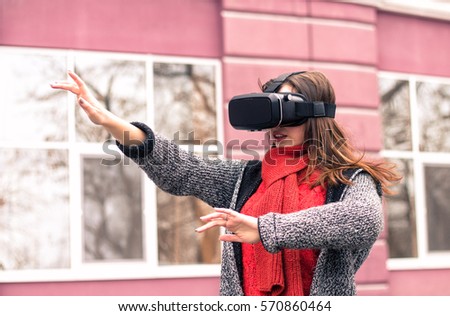 virtual reality headset, VR glasses, VR goggles - beautiful young girl playing with virtual reality headset or 3d glasses  on the street interested by 360 image