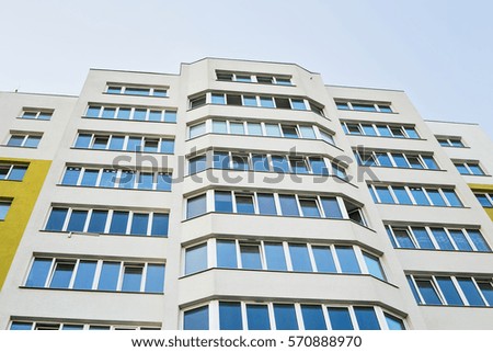Facade of new residential building with balcony. Modern apartment building and blue sky.