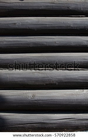 Texture, background. The house is assembled from wooden logs. A log house made of pine, cedar, larch. Logs wooden house painted black.