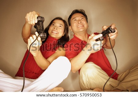Man and woman playing with handheld video game
