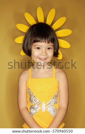 Young girl standing against yellow background
