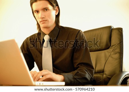 Executive in office using laptop, portrait