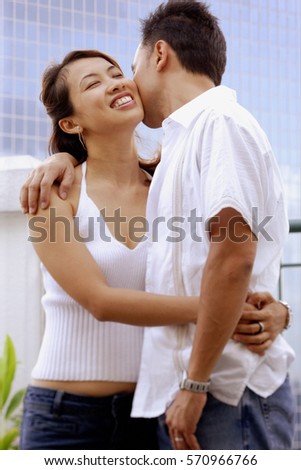 Man kissing woman on cheek