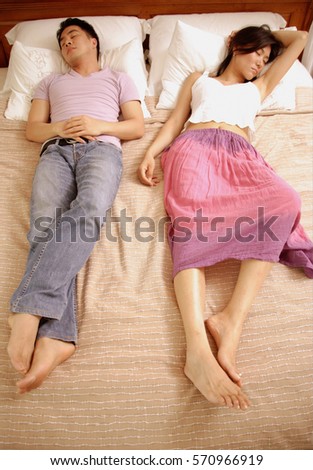 Couple lying in bed, side by side