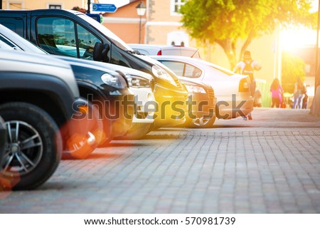 Parking of cars near the sidewalk for pedestrians, the cars stand in row on Parking in the old town. Royalty-Free Stock Photo #570981739