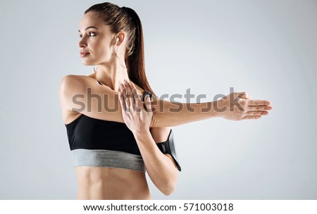 Young girl doing stretching on a grey background