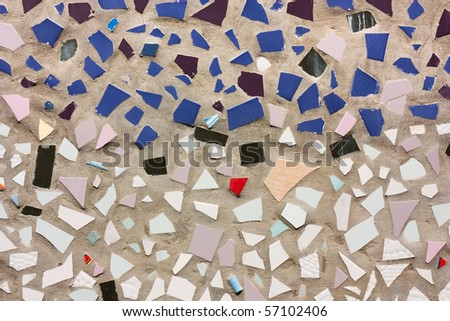 concrete wall decorated with colored pieces of ceramic tile - patchwork of ceramics fragments - mosaic