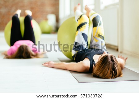 Two young women exercising with fitness balls at a bright fitness studio
 Royalty-Free Stock Photo #571030726