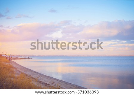 Sky background on sunset, seafront. Nature composition. Panoramic sunset sky background. Taganrog Bay, Azov sea. Beautiful sunset over sea with reflection in water, majestic clouds in the sky.