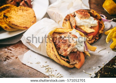 Greek food. Gyros souvlaki wrapped in a pita bread on a wooden background