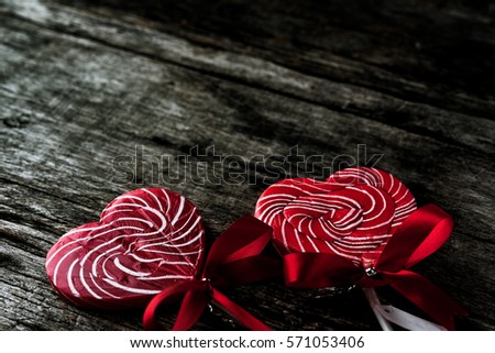 Heart shaped lollipop on background wooden. (Dark Tone Color Image)