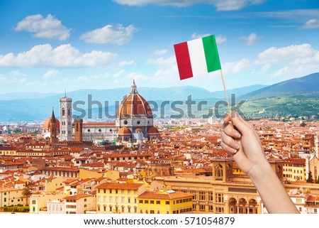 Hand with Italian flag and cityscape of Florence