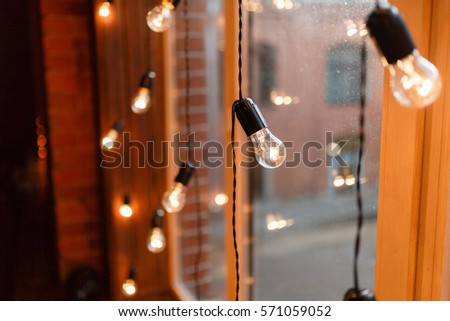 The lights on the garland on the window background 