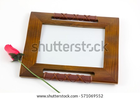 Wooden picture frame with rose flower isolated on white background. Close up  of photo frame with flower.