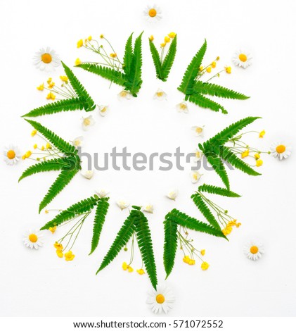 Wreath with jasmine, chamomile, ranunculus and leaves of green fern on white background. Flat lay.