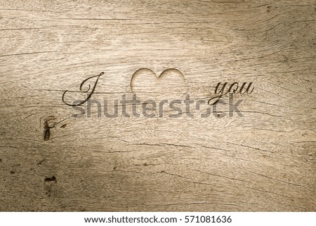 carve i love you on wood background, vintage filter effect, top view 