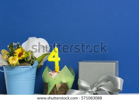 congratulatory cake and candle figure 4 four a bouquet of flowers in a decorative bucket and gray box gift.