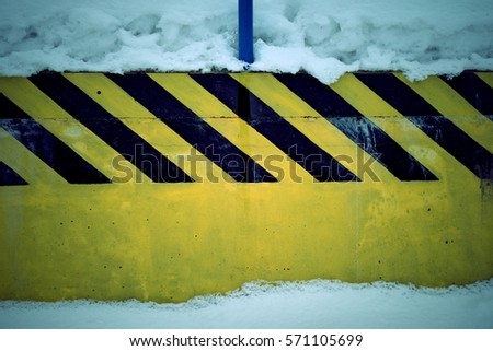 Concrete wall, black stripes on a yellow background