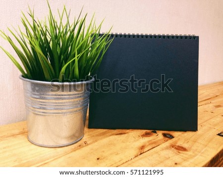 Month Concept, front view shows green grass of metal bucket and the calendar with blank space on wooden table