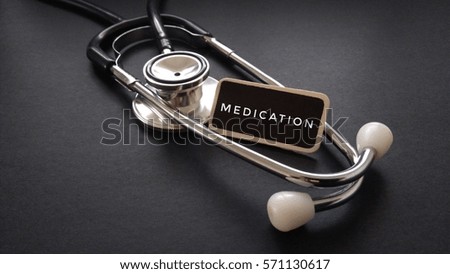 Wooden tag written with MEDICATION and stethoscope on black background. Medical and Healthcare Concept  