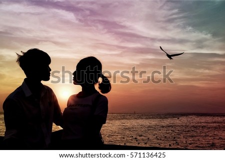 Couple silhouette on the beach at sunset on sweet sky background. Romantic picture for valentine.space for text.