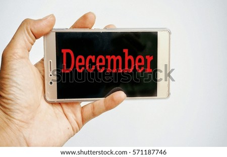 Conceptual image cropped hand holding mobile phone with text on white background