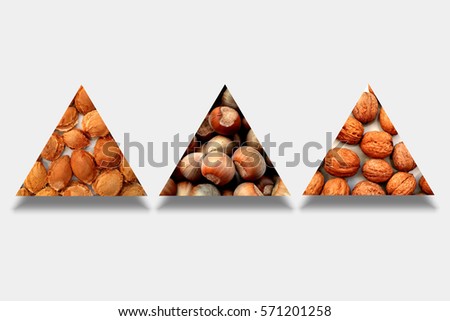 Various textures, namely apricot stones, hazelnuts and walnuts, inside three abstract triangles with shadow below, on gray background
