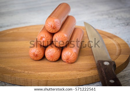 Raw Sausages on cutting Board on white rustic wooden background