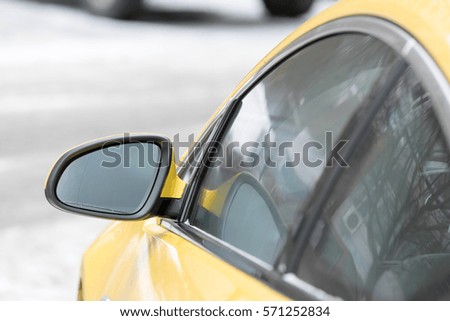 rear-view mirror of the yellow car in winter