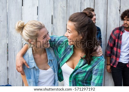 Women embracing each other while men standing in background