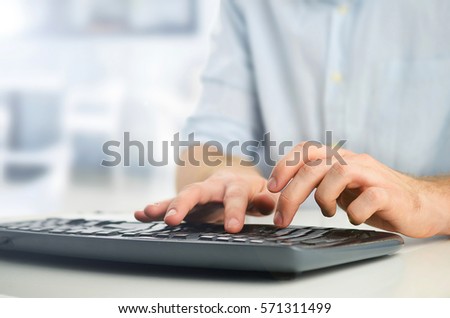Young businessman writing on keyboard