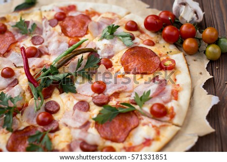 Hot true ITALIAN PIZZA. TOP VIEW Tasty traditional pizza on board on wooden table with decoration.