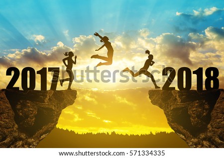 Girls jump to the New Year 2018 at sunset. Royalty-Free Stock Photo #571334335