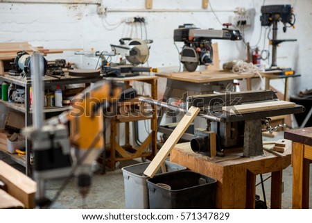 Tools and equipment used for carpentry in a dusty workshop Royalty-Free Stock Photo #571347829