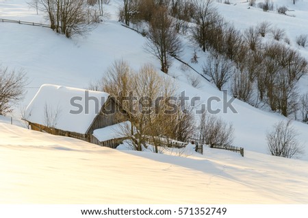 House on a hillside covered with snow and green trees on the sides, with hhory Blue Christmas forest in the background Winter landscape.