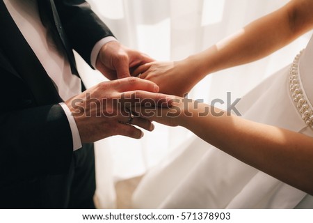 hands of bride and groom Royalty-Free Stock Photo #571378903