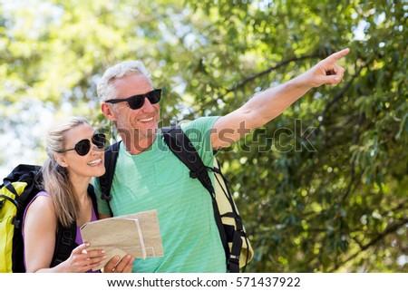 Couple pointing and holding a map on the wood