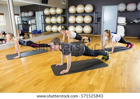 Workout Friends Doing Pushups On Mat In Gym