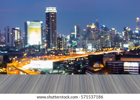 Opening wooden floor, blurred bokeh light city downtown night view
