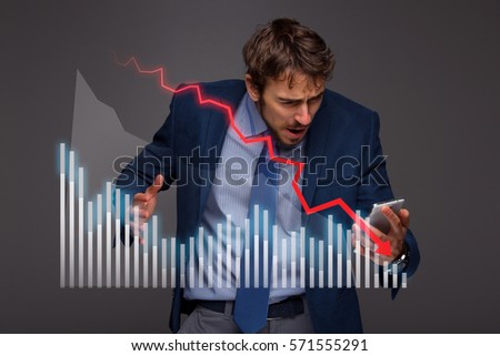 Businessman with chart in the fall, economy going down. Royalty-Free Stock Photo #571555291