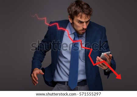 Businessman with chart in the fall, economy going down. Royalty-Free Stock Photo #571555297