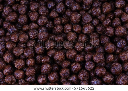 Chocolate breakfast cereal texture. Cereal balls as background. Chocolate corn balls wallpaper background cover. Cereals texture concept. 